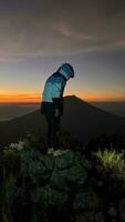 The Man greets the sunrise in the mountains. A man greet the dawn. West Java, Indonesia, March 16, 2023 photo