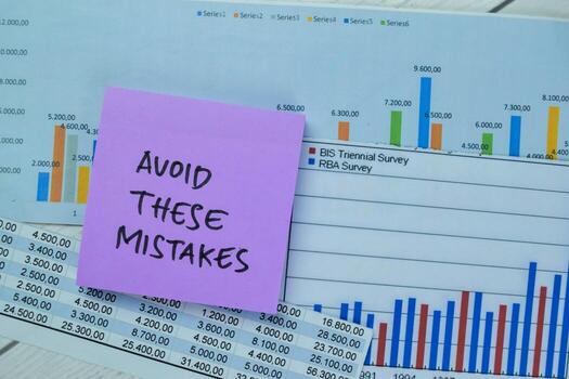 Concept of Avoid These Mistakes write on sticky notes isolated on Wooden Table. photo