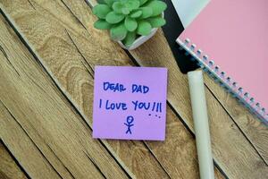 Concept of Dear Dad I Love You write on sticky notes isolated on Wooden Table. photo