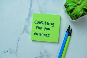 Concept of Consulting For You Business write on sticky notes isolated on Wooden Table. photo