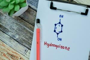 Concept of Hydroquinone write on paperwork, structural chemical formula isolated on Wooden Table. photo