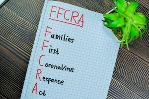 Concept of FFCRA - Families First Coronavirus Response Act write on book isolated on Wooden Table. photo