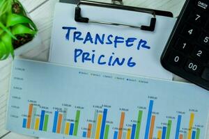 Concept of Transfer Pricing write on paperwork isolated on Wooden Table. photo