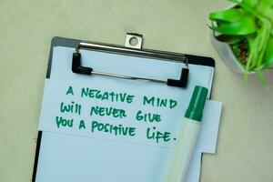 Concept of A Negative Mind Will Never Give You A Positive Life write on sticky notes isolated on Wooden Table. photo