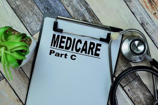 concepto de seguro médico del estado parte C escribir en papeleo con estetoscopio aislado en de madera mesa. foto