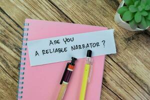 Concept of Are You A Reliable Narrator write on sticky notes isolated on Wooden Table. photo
