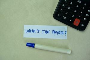 Concept of What's The Payoff write on sticky notes isolated on Wooden Table. photo