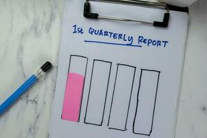 Concept of 1st Quarterly Report write on paperwork and bar graph isolated on Wooden Table. photo