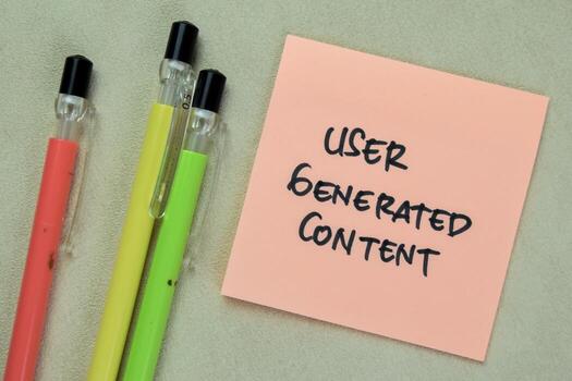 Concept of User Generated Content write on sticky notes isolated on Wooden Table. photo