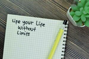 Concept of Life Your Life Without Limits write on book isolated on Wooden Table. photo