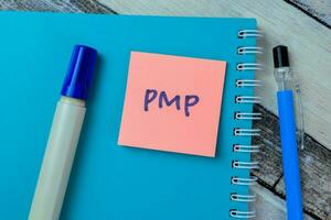 Concept of PMP write on sticky notes isolated on Wooden Table. photo
