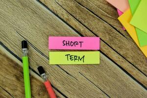 Concept of Short Term write on sticky notes isolated on Wooden Table. photo