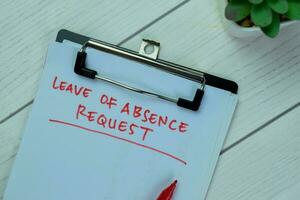 Concept of Leave of Absence Request write on paperwork isolated on Wooden Table. photo