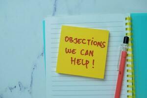 Concept of Objections We Can Help write on sticky notes isolated on Wooden Table. photo