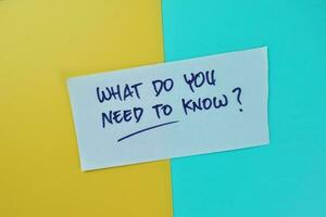 Concept of What Do You Need To Know write on sticky notes isolated on Wooden Table. photo