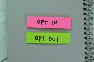 Concept of Opt in or Opt Out write on sticky notes isolated on Wooden Table. photo