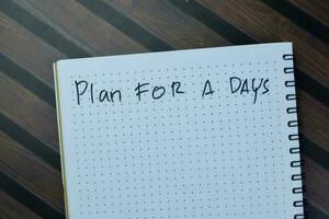 Concept of Plan For a Days write on book isolated on Wooden Table. photo