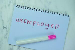 Concept of Unemployed write on book isolated on Wooden Table. photo