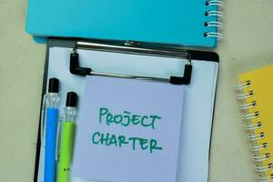 Concept of Project Charter write on sticky notes isolated on Wooden Table. photo