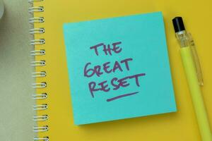 Concept of The Great Reset write on sticky notes isolated on Wooden Table. photo