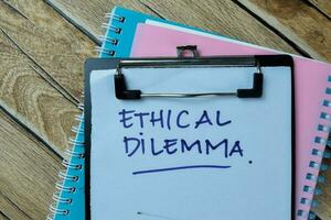 Concept of Ethical Dilemma write on paperwork isolated on Wooden Table. photo