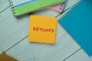 Concept of Ketones write on sticky notes isolated on Wooden Table. photo