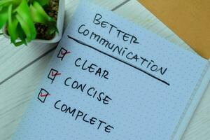 Concept of Better Communication write on book with keywords isolated on Wooden Table. photo