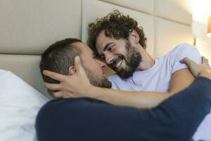 Happy gay couple having tender moments in bedroom - Homosexual love relationship and gender equality concept photo