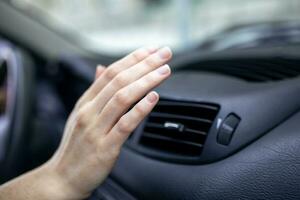 woman adjusting the cooling inside her car, Closeup of hand driver checking adjusting air from conditioning the cooling system with flow of cold air in car. photo