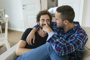 Loving Same Sex Male Gay Couple Lying On Sofa At Home And Relaxing, cuddling Together photo