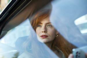 Beautiful Businesswoman is Commuting from Office in a Backseat of Her Luxury Car. Entrepreneur Passenger Traveling in a Transfer Taxi in Urban City Street photo