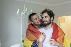 cariñoso masculino gay Pareja adentro. hombre abrazando su novio desde detrás a hogar. gay Pareja celebrando orgullo mes foto