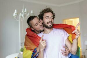 cariñoso masculino gay Pareja adentro. hombre abrazando su novio desde detrás a hogar. gay Pareja celebrando orgullo mes foto