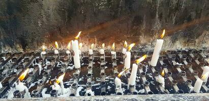 Prayers candle in one quite praying place, each candle represents the hope and spirit of the prayers photo