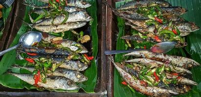 Seafood dish served on the table and plate from above with different kind of dish from fried fish barracuda, snapper, tuna jaws, and also mix of tropical vegetables photo