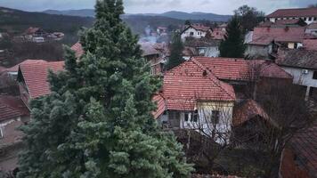 lado a lado telhados do casas dentro uma sérvio Vila, aéreo Visão video