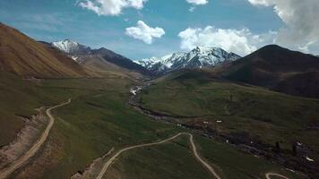 tierras altas con nubes y nevadas picos, aéreo ver video