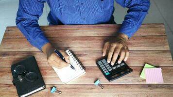 top view of man hand using calculator and writing on notepad video