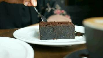 Frau Essen Brownie auf Teller auf Cafe Tabelle video