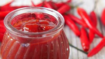 Chili and tomato sauce in a small jar on table video