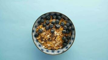 Desayuno de cereales y bayas azules en un tazón en la mesa video