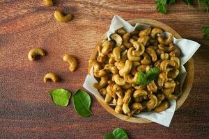 Cashew Nut, in Indonesia known as Kacang Mete or Mede. Served in a bowl on wood background photo