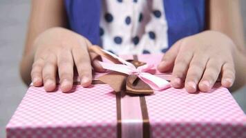 concept de fête des mères de la main de lenfant tenant une boîte cadeau de couleur rose video