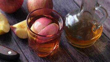 apple vinegar in glass bottle with fresh green apple on table video