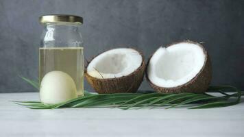 slice of fresh coconut and bottle of oil on a table video