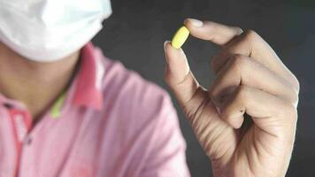 Young man in face mask holding pills video