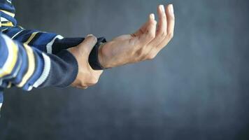 man suffering pain in hand against black background video