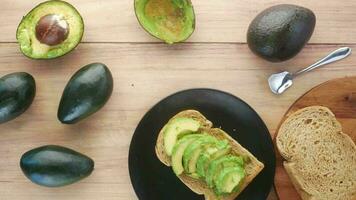 Avocado on slice of a brown bread on table video