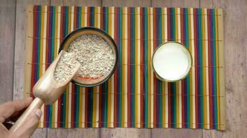 uncooked oats flakes on colorful background, top down video