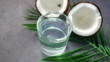 tranche de noix de coco fraîche et verre d'eau de coco sur table video